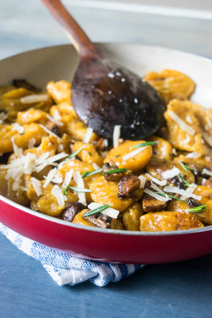 Fluffy, pillowy pumpkin gnocchi with earthy caramelized mushrooms, rosemary and parmesan. An easy, warming dish for chilly winter nights! | www.thelastcookie.ca