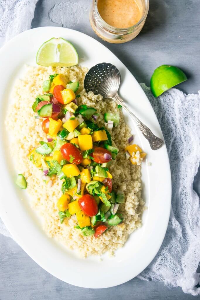 This incredible couscous salad is light and refreshing with sweet mangoes, cucumbers, summer vegetables and a spicy tahini dressing. A delicious blend of flavors for summers! | www.thelastcookie.ca