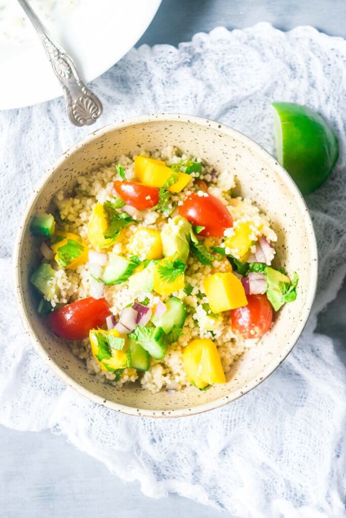 This incredible couscous salad is light and refreshing with sweet mangoes, cucumbers, summer vegetables and a spicy tahini dressing. A delicious blend of flavors for summers! | www.thelastcookie.ca